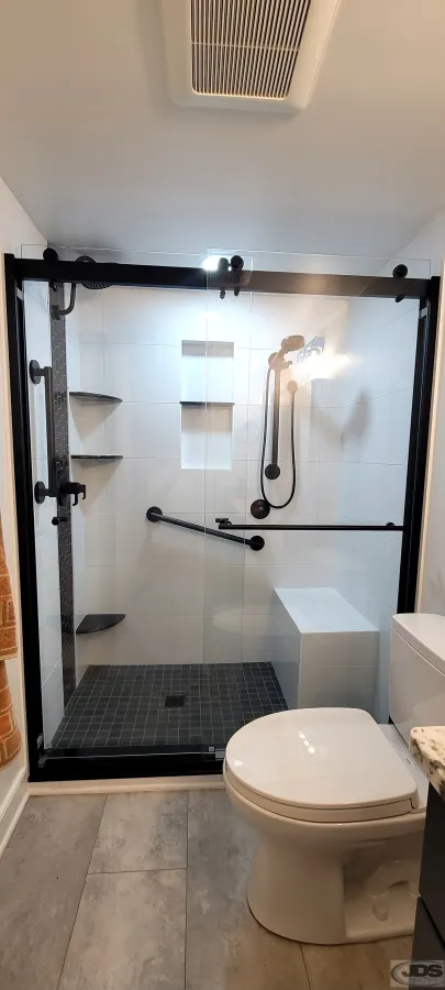JDS Bath tile walk in shower built in bench toilet black and white tile semi frameless glass bypass door centeral va