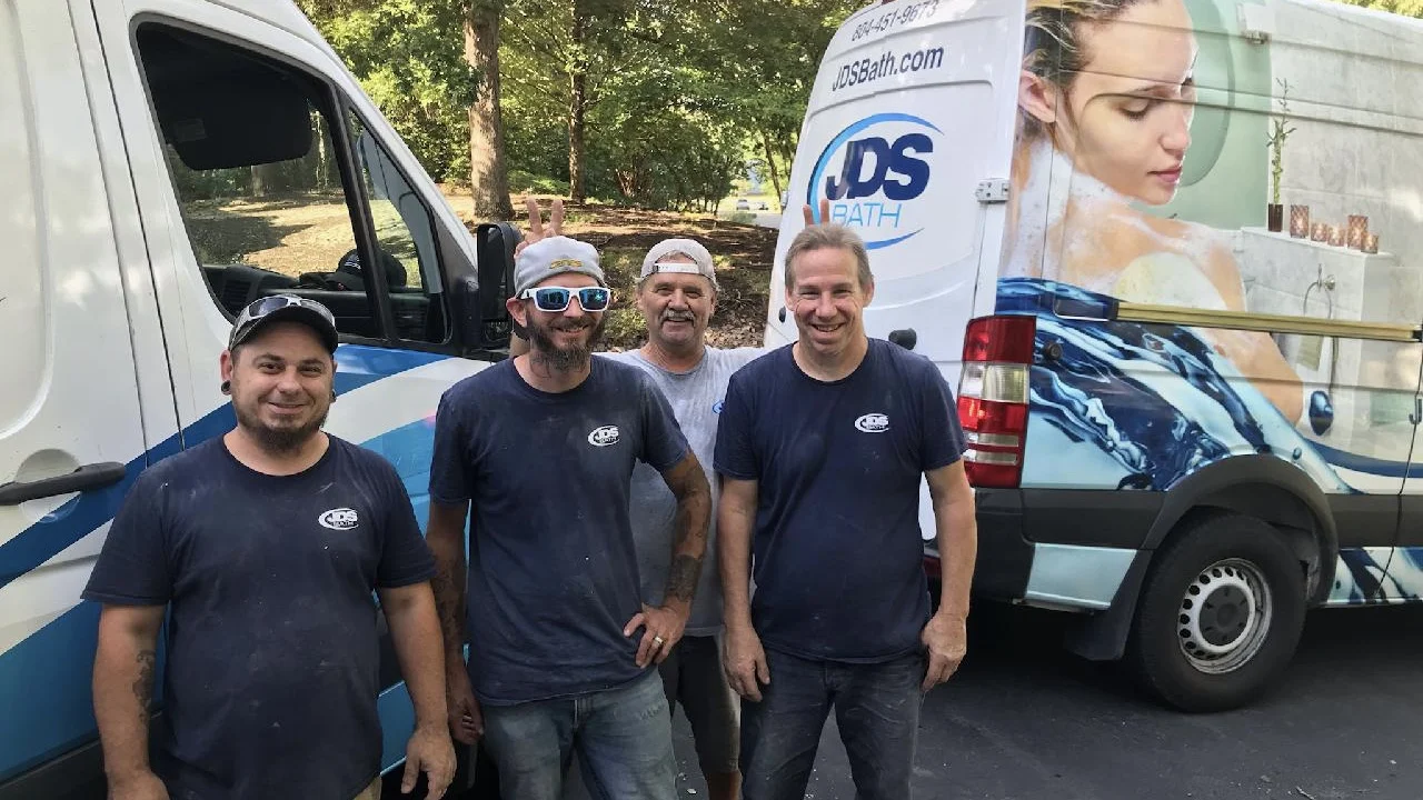 JDS Bath remodeling team stands in front of company trucks
