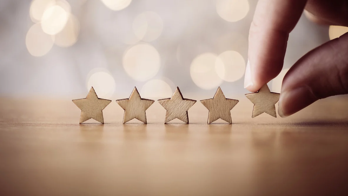 Five small wooden stars lined up on table
