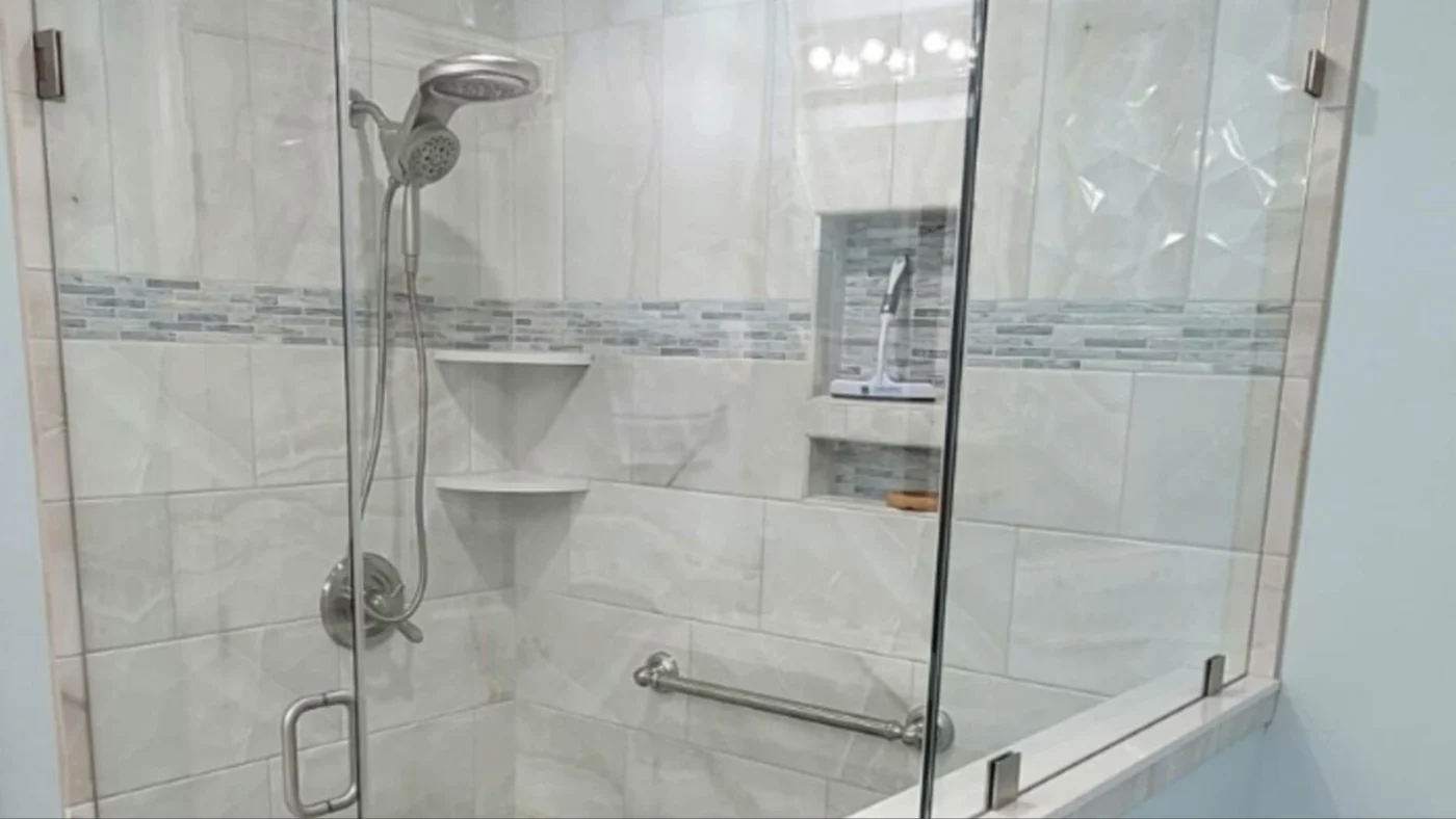 A bathroom remodel with a glass wall and shower door