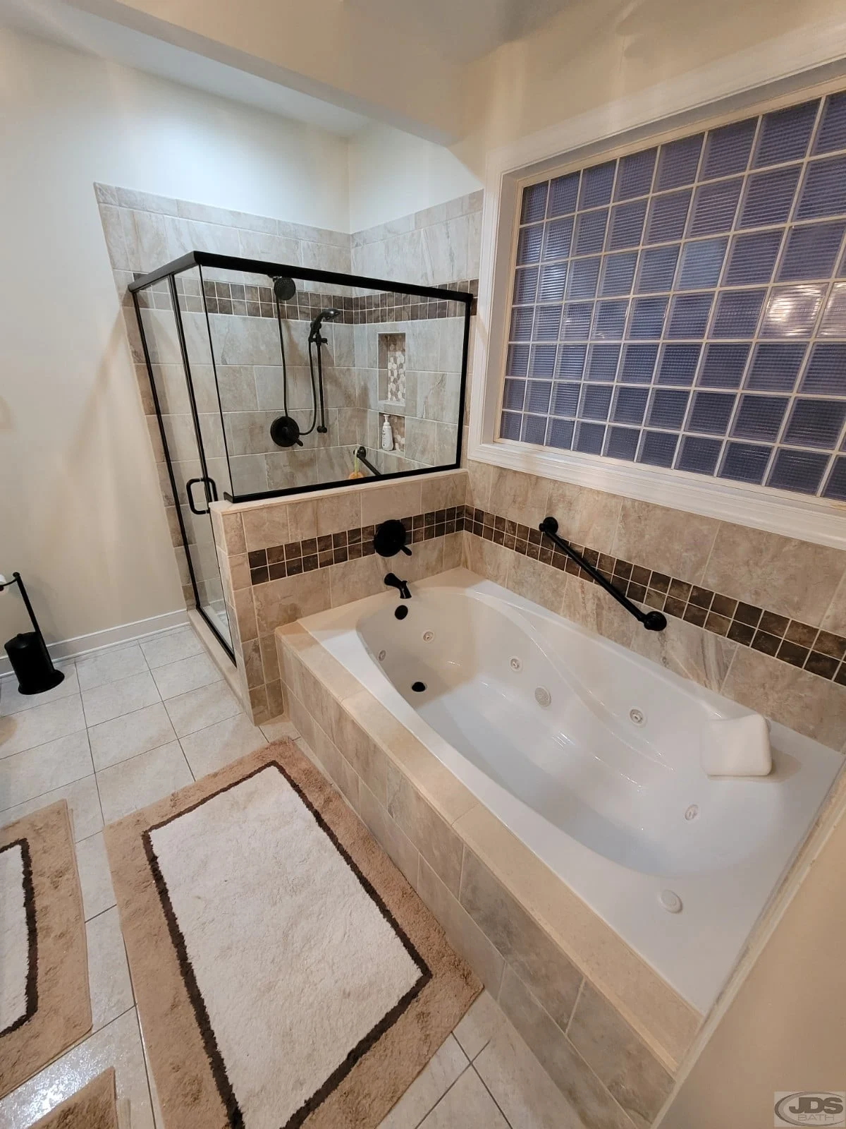 Newly installed bronze clear glass shower door, panel, and knee wall