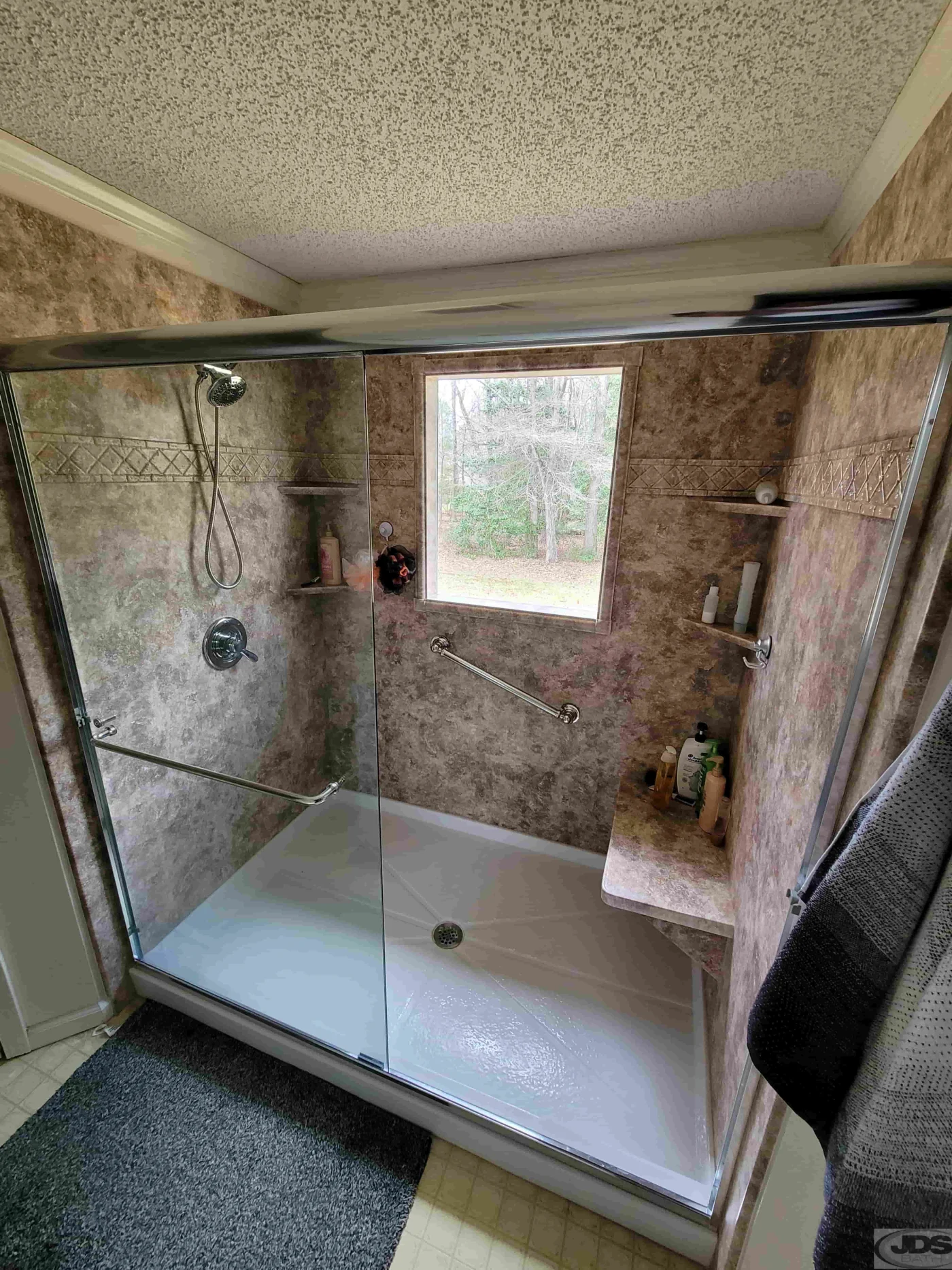 New bathroom with chrome semi-frameless clear glass door and acrylic shower