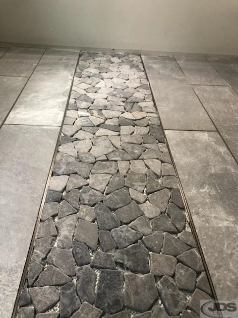 Closeup of a stone mosaic in the new shower.