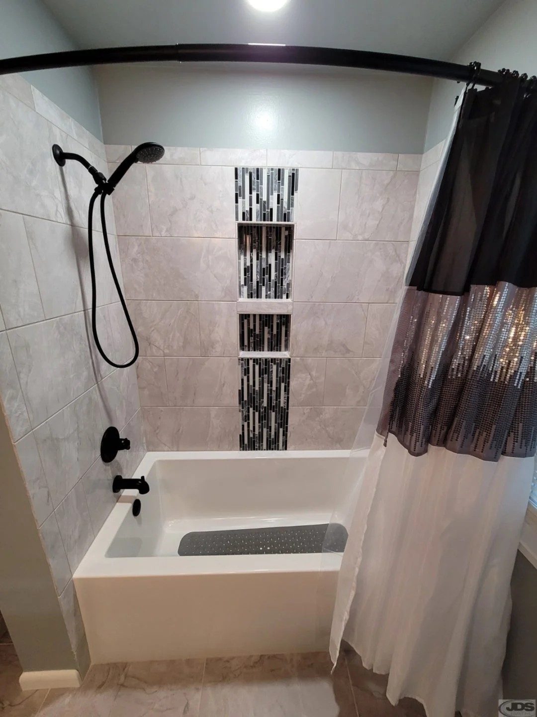A tile and acrylic bathtub and shower