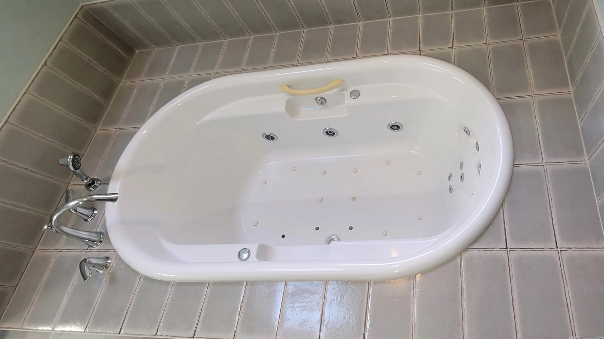A jetted bathtub with a tile surround