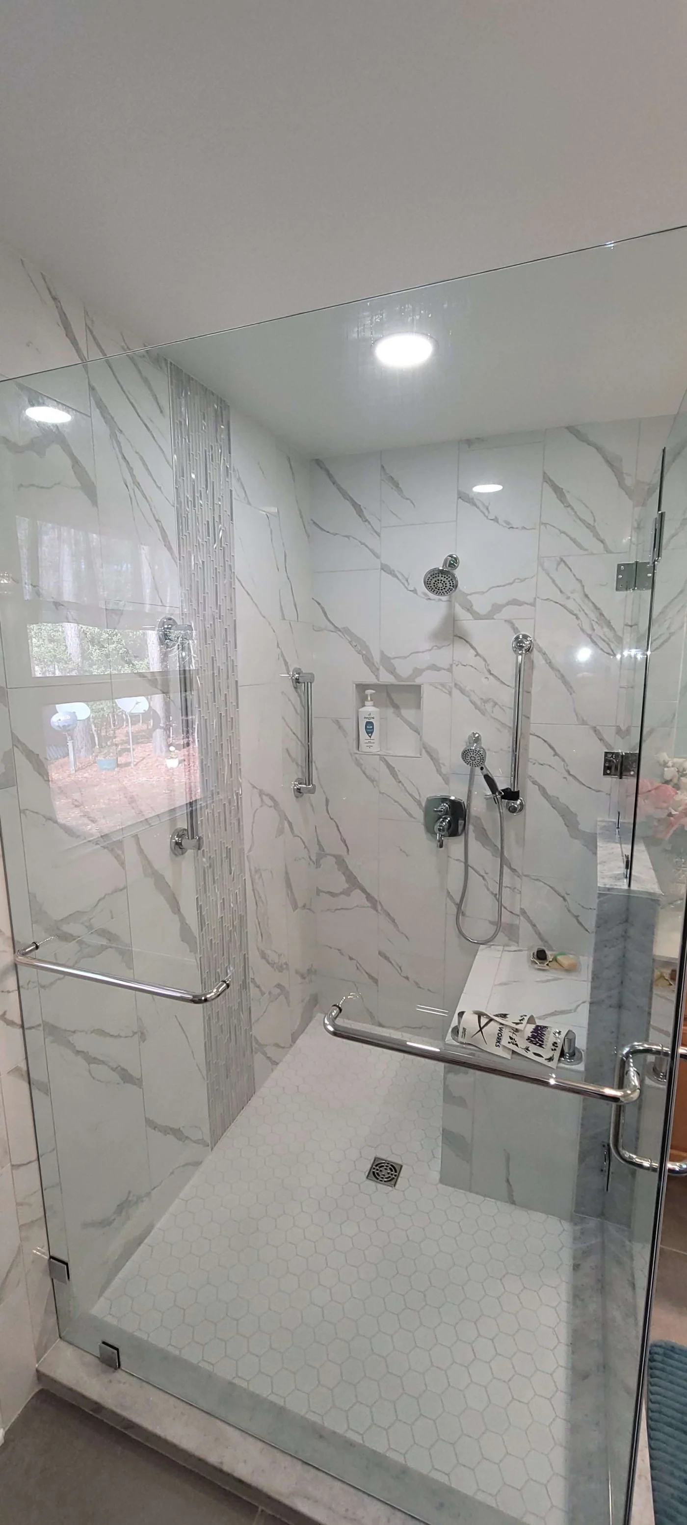 Large white walk-in shower with glass enclosure