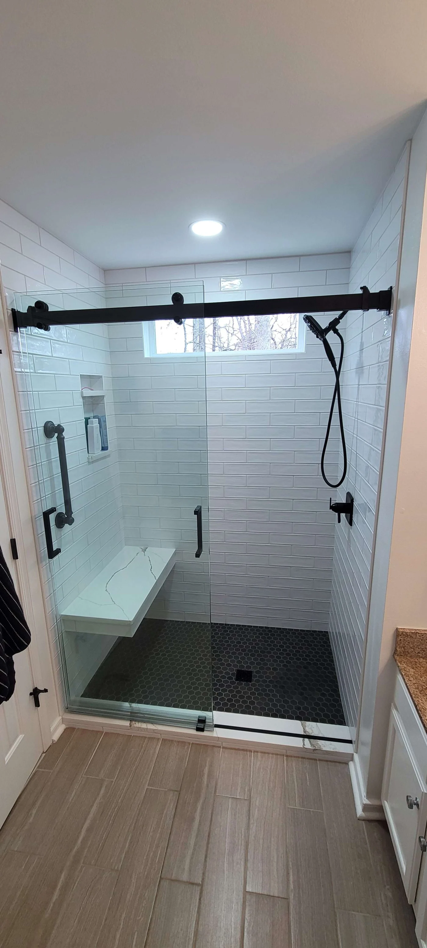 Sleek tile walk-in shower with bench and grab bars